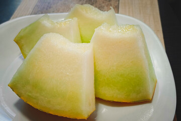 japanese melon cut or divided on a white block in kitchen, Homemade style.