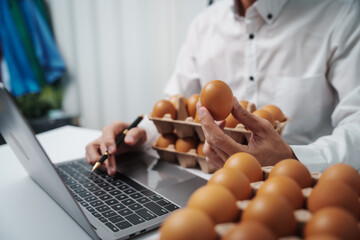 Obraz premium A businessman checks eggs at a work table in a factory, ensuring cleanliness and freshness. Food safety experts inspect quality during sorting on the production line, adhering to industry standards