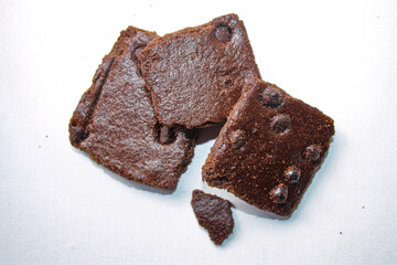 Dry brownies with chocolate chips on white background