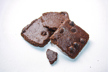 Dry brownies with chocolate chips on white background
