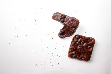 Dry brownies with chocolate chips on white background