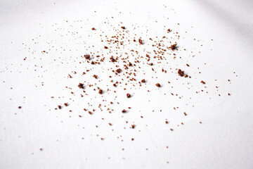 Scattered crumbs of chocolate biscuits on white background