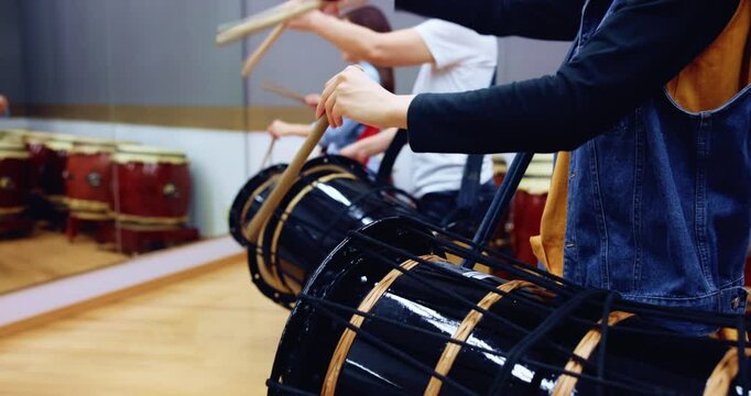 Music, traditional drums and rhythm with taiko teacher in studio for class, performance or practice. Japanese art, women hands and instrument with bachi, demonstration or talent for percussion group