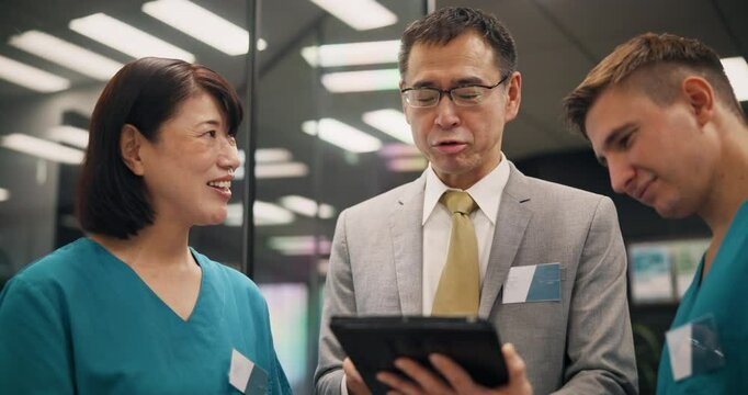 Doctor, nurses and meeting with tablet in clinic for staff management and healthcare service delivery. Medical admin, mature health manager and team with mentor support and hospital schedule in Japan