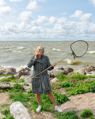 landscape with the sea during a storm, a woman enjoys the wind on the seashore