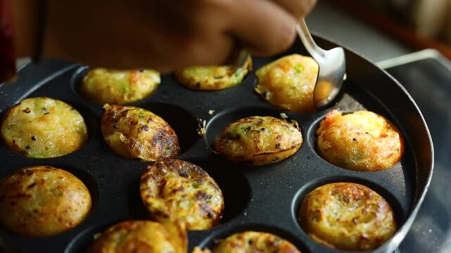 Appam or Mixed dal or Rava Appe South Indian dish preparation on iron pan