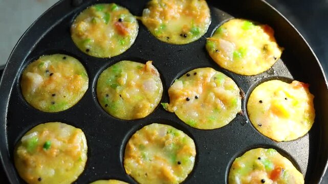 Appam or Mixed dal or Rava Appe South Indian dish preparation on iron pan