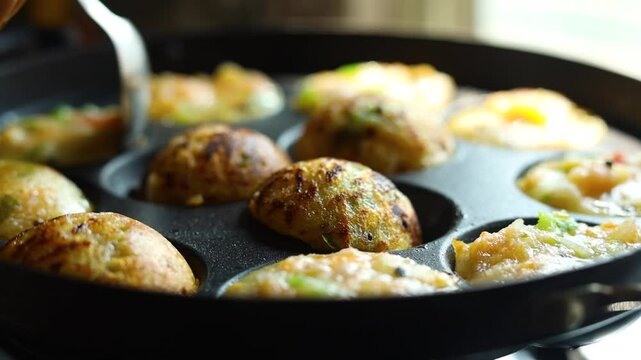 Appam or Mixed dal or Rava Appe South Indian dish preparation on iron pan