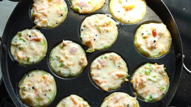 Appam or Mixed dal or Rava Appe South Indian dish preparation on iron pan