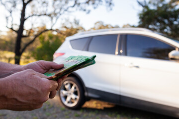 Middle aged mans hand holding one hundred dollar notes in Australian cash to pay for car