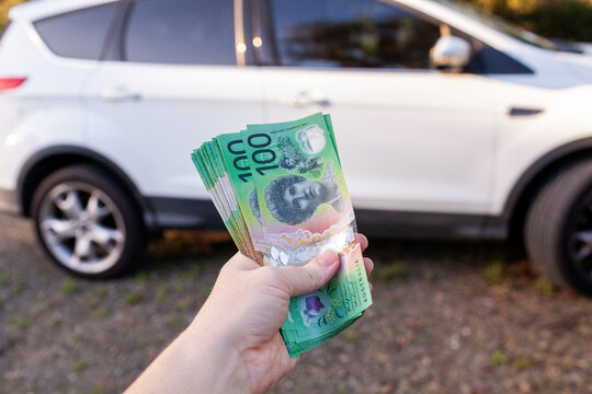 private car sale with woman holding wad of one hundred dollar notes