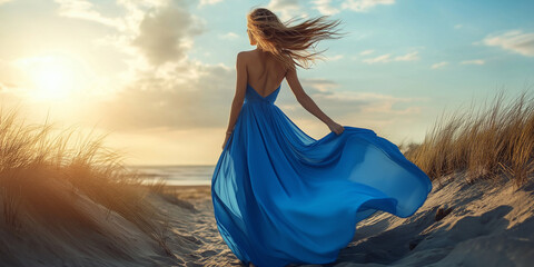 A woman gracefully adorned in a flowing blue gown stands by a windswept shoreline, her dress dramatically catching the breeze, under a vibrant sky.