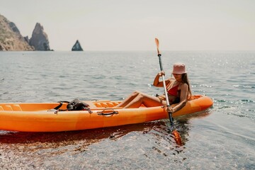 Obraz premium Kayak sea woman. Happy attractive woman with long hair in red swimsuit, swimming on kayak. Summer holiday vacation and travel concept.