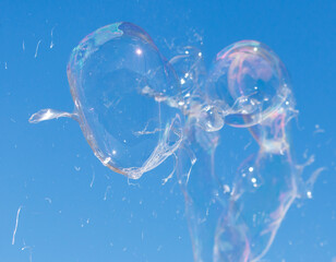 A bubble is floating in the air with a clear blue sky in the background