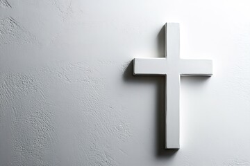Minimalistic white cross on textured wall with shadows