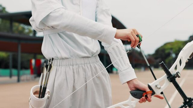 Archery, bow and draw with person and arrow in Japan for shooting game, challenge and target practice. Competition, start and weapon with sports gear and athlete in field for score, aim or bullseye
