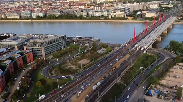 Timelapse of the southern part of downtown Budapest from above, as cars, trams and trains pass through the Rakoczi Bridge over the River Danube during daytime.