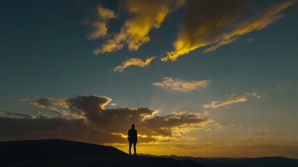 silhouette of a person standing on a hill