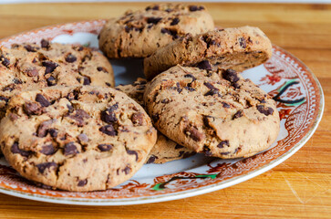 Chocolate chip cookies on a plate with a white background