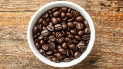 Fototapeta premium A bowl filled with roasted coffee beans on a wooden surface.