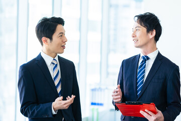 資料を見ながら打ち合わせするビジネスマン
