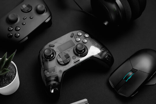 gamer work space concept, top view a gaming gear, mouse, keyboard, joystick on black table background.