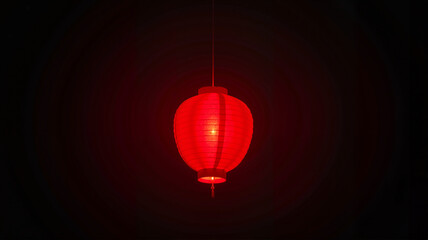 Obraz premium Single glowing red lantern against dark background