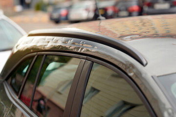 Vehicle exterior damaged by hail with visible dents and scratches on roof, aftermath of a severe...
