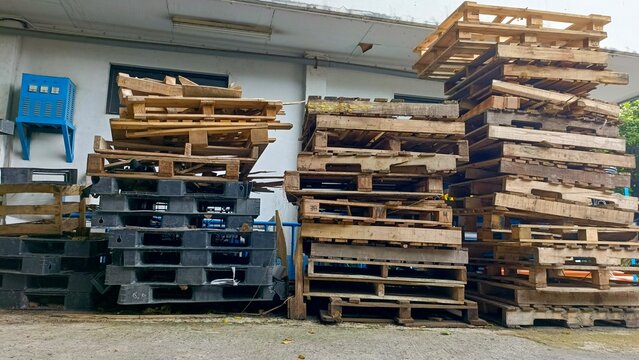 Jakarta, Indonesia-November 24, 2024-Wooden pallets and plastic pallets are stacked up in a messy manner