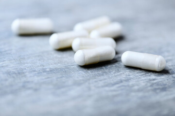 Beta-alanine capsules. Bodybuilding food supplements on wooden background. Soft focus. Close up. Copy space.