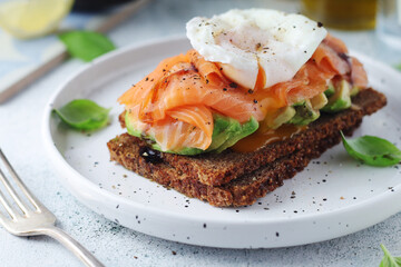A rye bread sandwich with avocado and salmon