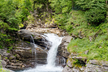 magnificent mountain landscape, majestic cliffs, mountain river waterfall, meadow vegetation, Swiss Alps