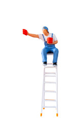 A miniature figurine of a painter seated on a ladder, holding a paint can and brush.isolate on...