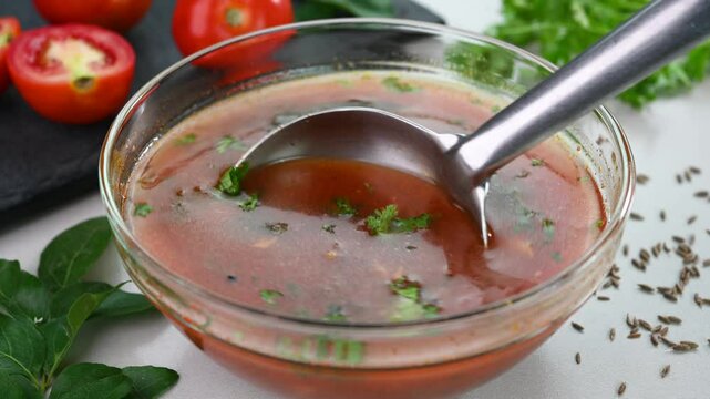 Serving rasam Indian spicy dish.
