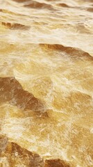 Obraz premium Golden textured landscape with shimmering waves reflecting warm light, creating an ethereal and calming atmosphere.