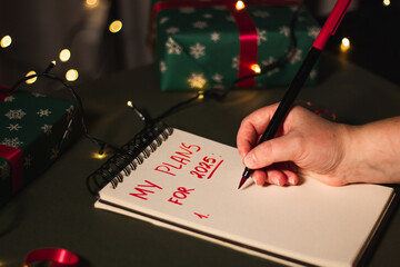 Notebook with written plans for new year 2025 in Christmas decoration. Making plans for future....