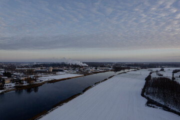 Lielupe river in Latvia near Jelgava town. Snow cowered fields. Wintertime aerial view
