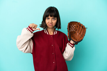 Young mixed race player woman with baseball glove isolated on blue background showing thumb down...