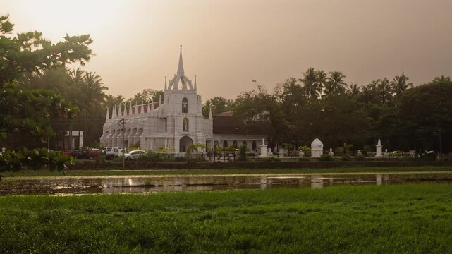 4K Timelapse footage of the Neo-Gothic Mae de Deus Catholic church in Saligao Goa at dusk night with traffic light trails and illuminated church and people visiting the church
