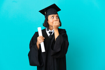 Young university graduate girl over isolated blue background nervous and scared putting hands to...