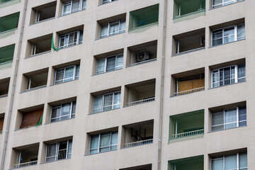 A close-up of a residential apartment building facade. The repeating square balconies and windows create a rhythmic architectural pattern. 