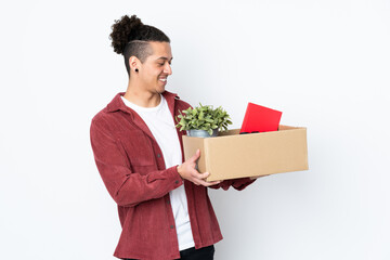 Caucasian man making a move while picking up a box full of things over isolated white background...