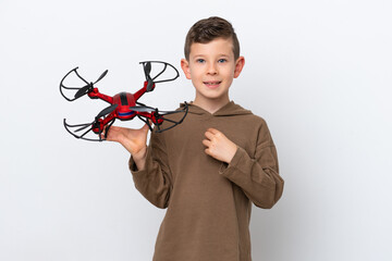 Little Caucasian boy holding a drone isolated on white background with surprise facial expression