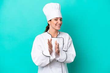 Young caucasian chef woman isolated on blue background applauding after presentation in a conference