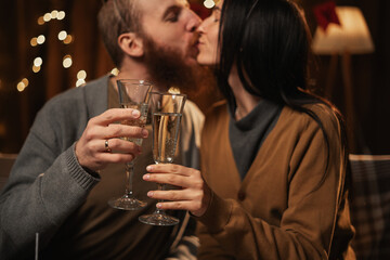 Happy young couple in love holding glasses, drinking champagne, celebrating Birthday at home together, having romantic dinner, bonding.