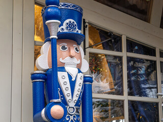 Decorative blue figurine of a fairy-tale character and a Christmas tree. Festive decorations in...