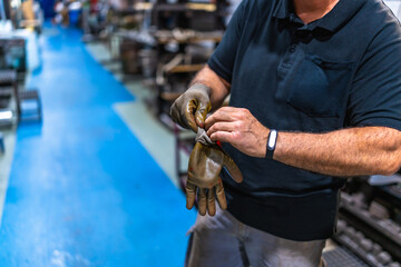 Worker putting on protective gloves in a factory