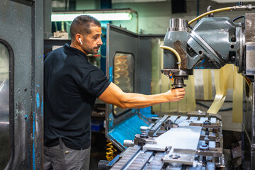 Operator working with milling machine in factory