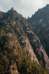 Temple atop a forested mountain cliff in Bhutan.