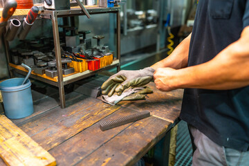 Worker putting on safety protective gloves in a metallurgic factory